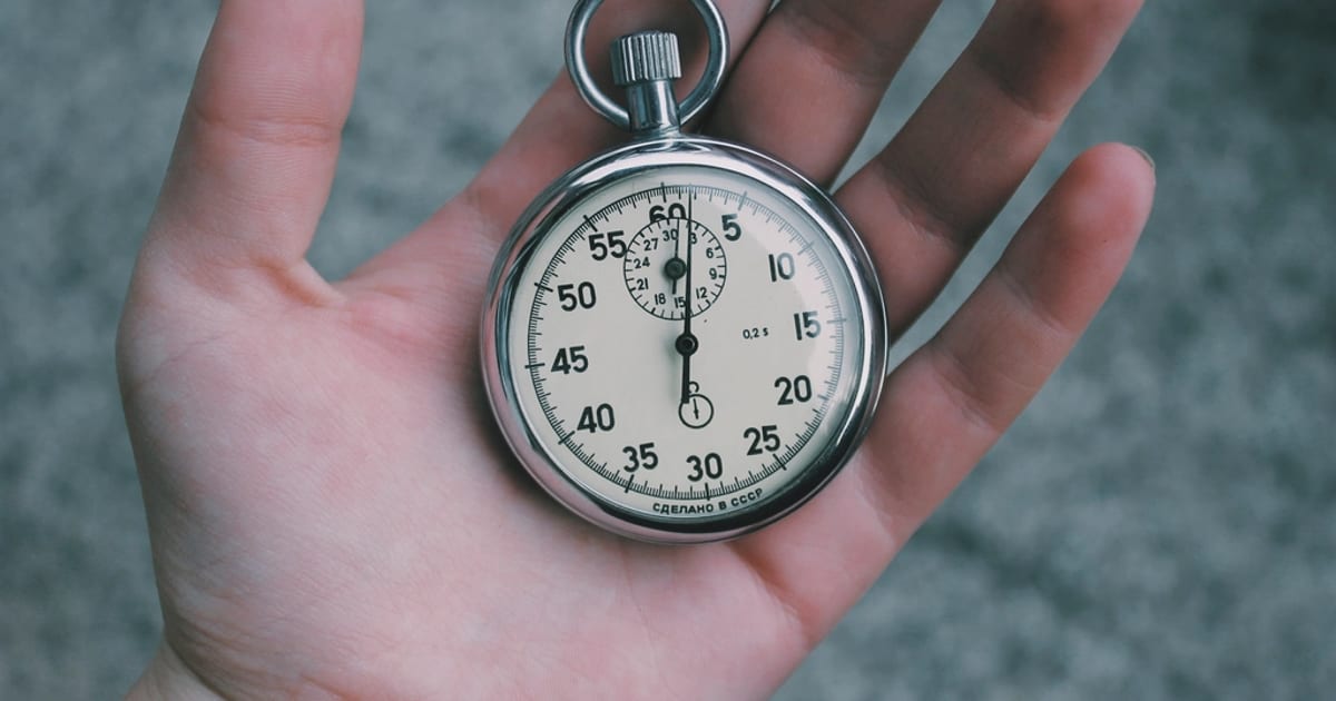 A mechanical stopwatch held in an open hand