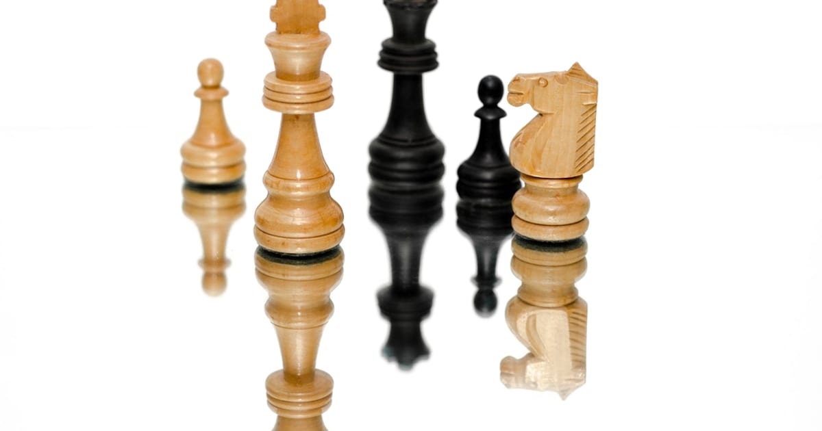 Black and white chess kings and queens standing in a group