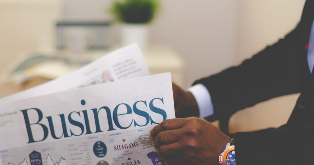 A person reading the business section of a newspaper